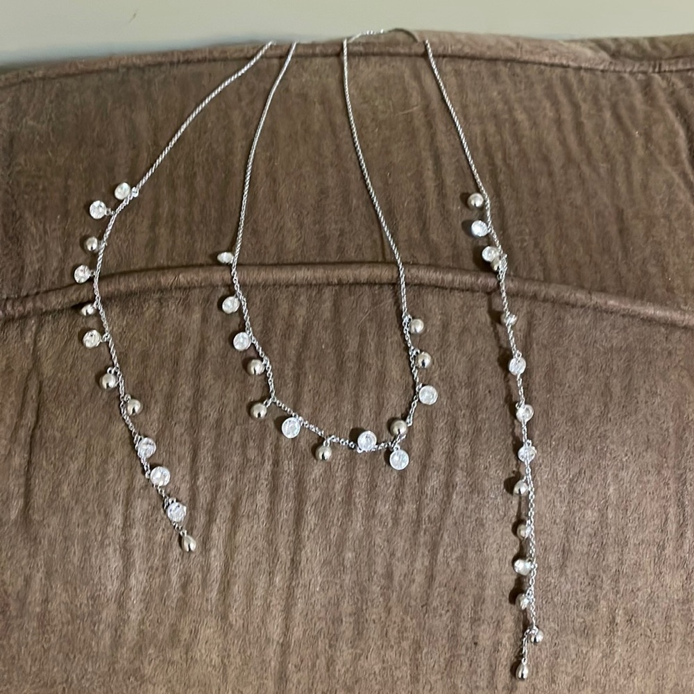 This is a silver necklace with white Swarovski crystals. It is a wrap necklace.